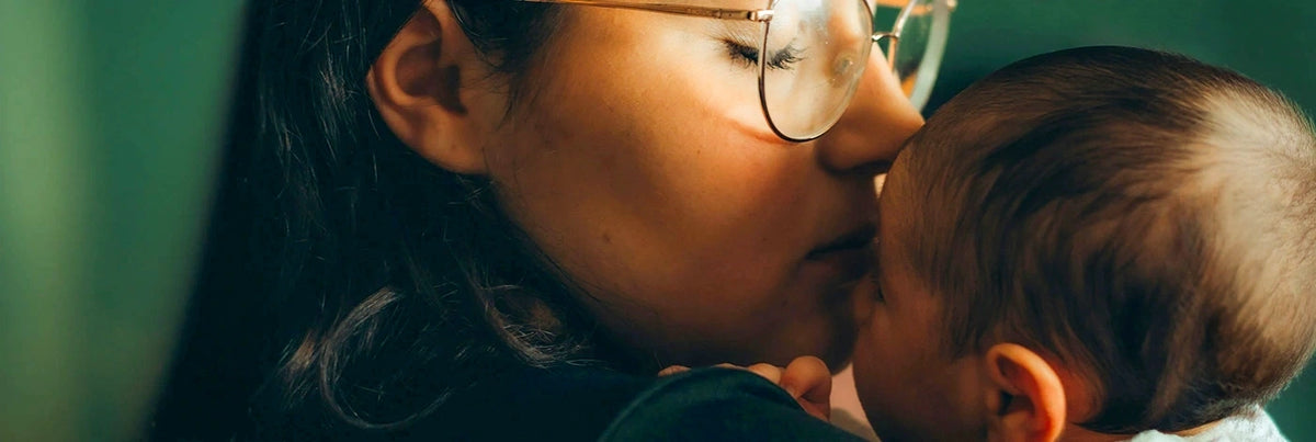 A woman kissing a baby. 
